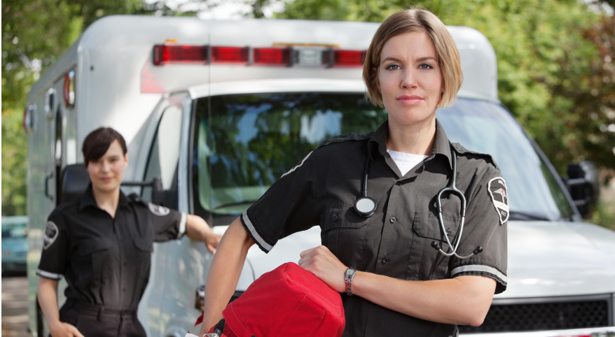 Two woman standing Infront of a non emergency patient transfer van 